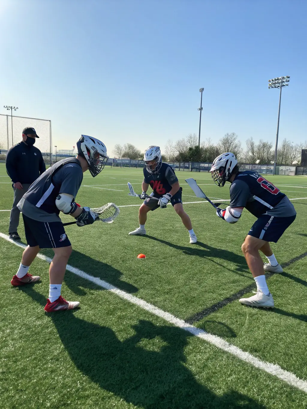A team of lacrosse players from Bourges Lacrosse are strategizing during a game, emphasizing the importance of teamwork and communication.